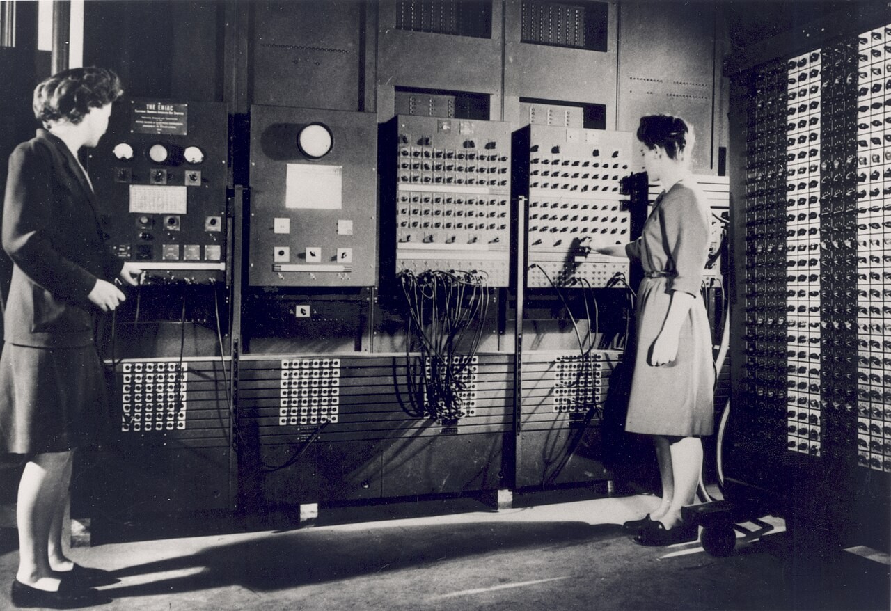 Betty Jennings and Frances Bilas stand beside the ENIAC control panels.